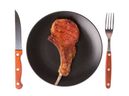dish of Grilled pork ribs with fork and knife isolated on white backgroundの写真素材