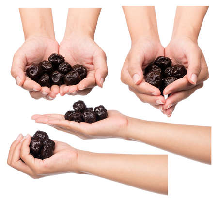 Set of hand holding Dried prune isolated on white backgroundの写真素材