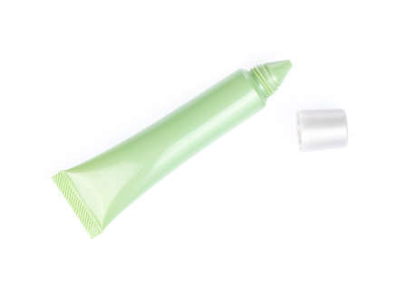 Green cosmetic tube isolated on a white background.