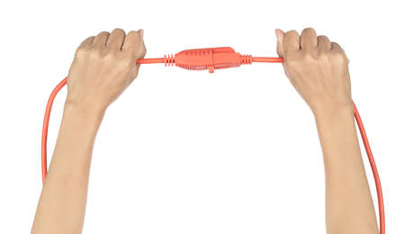 Hand holding orange extension cord isolated on white background