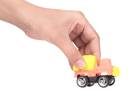 Hand holding toy truck Concrete mixe isolated over white backgroundの写真素材