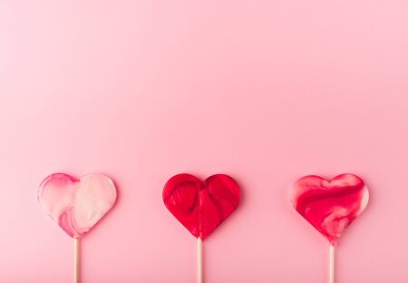 Pink romantic holiday background with heart-shaped sweet candies. Decorative card for St. Valentine's Day with space for text. Love theme.の写真素材
