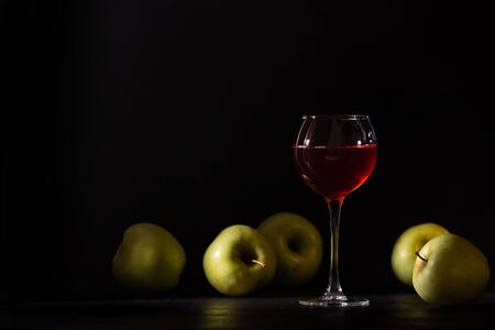 A glass of red fruit wine. Apples fresh crop, still life in a low key. Copy space. Banner for cafe, winery and restaurant.の写真素材
