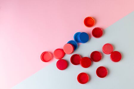 Plastic bottle caps for drinking water on a colored background. Recycling, waste separation,...