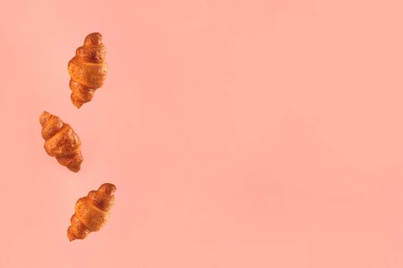Croissants flying on pink background. Levitation scene. Copyspace.の写真素材