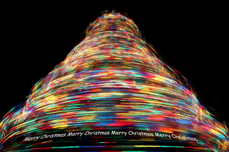 Merry Christmas - Long Exposure of Rotating Christmas Tree with Cycling Optical Fibre Lights against a black backgroundの写真素材