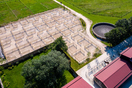 Outdoor boxes paddocks for horses on a farm. Wood fences. Aerial Drone Photoの写真素材