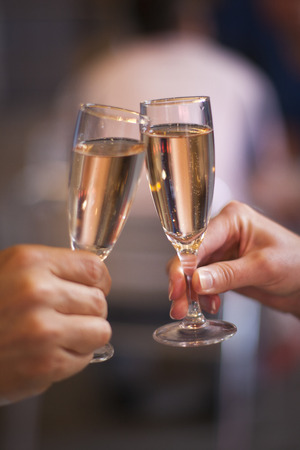 Celebration: cheering with a glass of champagneの写真素材