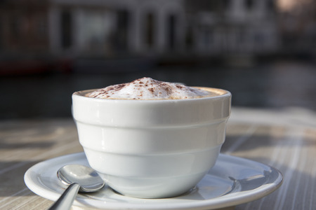 Fresh Italian cappuccino on a cafe terrace tableの写真素材