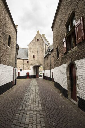 Old city gateway with small cobble stone alley and brick building,Zierikzee, the Netherlandsのeditorial素材