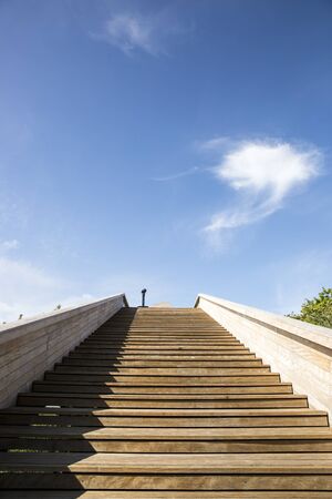 wooden staircase leading to a cloudの写真素材