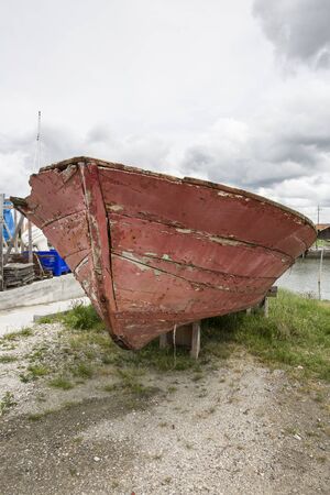 Old red wooden boat off the waterの写真素材