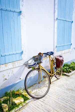 Seaside holidays house with blue wooden shutters with a bike in frontの写真素材