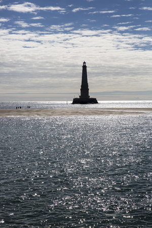 view over the sea with silhouette of the historical renaissance lighthouse of Cordouan at sunset, Gironde estuary, Franceの写真素材