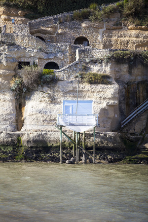 traditional french fisherman's wooden hut at the bottom of the limestone cliff in the estuary of Gironde, Meschers-sur-Girondeの写真素材