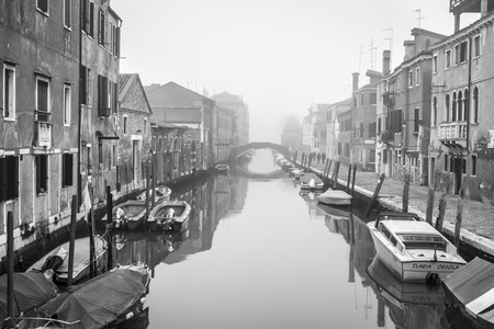 VENICE, ITALY â December 25, 2015: black and white typical romantic canal and street scene, with locals and tourists, in the winter mist in Cannaregio, Venice,のeditorial素材