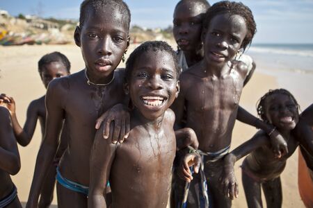 SENEGAL, Ndayane â November 9, 2013: Unidentified Senegalese children on the beach of Ndayane, playing and waiting for their father to come back from fishing . Despite poverty, Senegal kids stay smiling.のeditorial素材