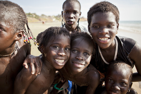 SENEGAL, Ndayane â November 9, 2013: Unidentified Senegalese children on the beach of Ndayane, playing and waiting for their father to come back from fishing . Despite poverty, Senegal kids stay smiling.のeditorial素材