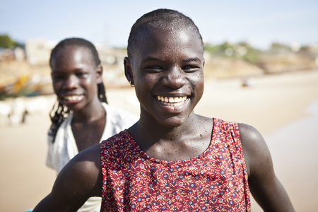 SENEGAL, Ndayane - November 9, 2013: Unidentified Senegalese children on the beach of Ndayane, playing and waiting for their father to come back from fishing . Despite poverty, Senegal kids stay smiling.のeditorial素材