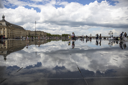 BORDEAUX, FRANCE - April 25, 2015: le Miroir d'Eau, water mirror near Place de la Bourse designed by landscape artist Michel Corajoud, full of people having fun one of 1st warm spring day of the yearのeditorial素材