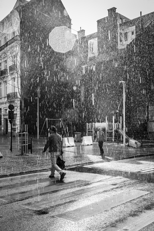 Brussels, Belgium - April 17, 2016: people calmly walking under summer stormy heavy rain in the city center of Brusselsのeditorial素材
