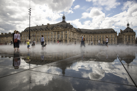 BORDEAUX, FRANCE - April 25, 2015: le Miroir d'Eau, water mirror near Place de la Bourse designed by landscape artist Michel Corajoud, full of people having fun one of 1st warm spring day of the yearのeditorial素材