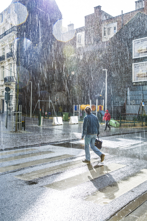 Brussels, Belgium - April 17, 2016: people calmly walking under summer stormy heavy rain in the city center of Brusselsのeditorial素材