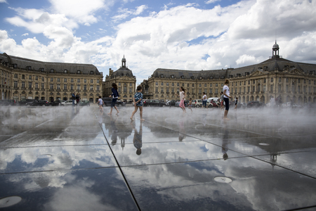 BORDEAUX, FRANCE - April 25, 2015: le miroir d'Eau, a water mirror near Place de la Bourse designed by landscape artist Michel Corajoud, full of people having fun one of 1st warm spring day of the yearのeditorial素材