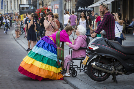 Amsterdam, the Netherlands - July 23, 2016: old woman talking with a man in a rainbow dress at Pride Walk, demonstration parade from Vondelpark to Dam Square, Pink Saturday Gay Euro Pride celebrationsのeditorial素材