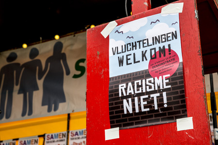 Amsterdam, The Netherlands - February 6,2016: public multi-cultural demonstration organized to protest against racism and islamophobia named "Refugees welcome, racism not!" Woman holding a sign saying later, you will be the black sheepのeditorial素材