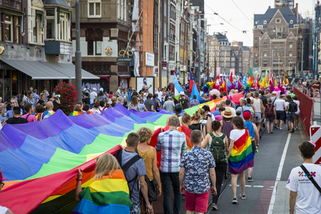 Amsterdam, the Netherlands - July 23, 2016: Pride Walk, Raimbow flag spread and held by people during the demonstration parade from Vondelpark to Dam Square during Pink Saturday Gay Euro Pride celebrationsのeditorial素材