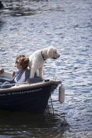 Amsterdam, the Netherlands- August 06, 2016: people watching the Euro Pride 2016 Gay Pride Parade from their boat with their dog. The Gay Pride Parade is an annual event for the protection of human rights and civil equalityのeditorial素材