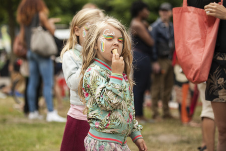 Amsterdam, The Netherlands - July, 5 2015: little girl eating an ice cream during Amsterdam Roots Open Air, a cultural festival held in Park Frankendael on 05/07/2015のeditorial素材
