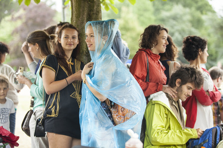 Amsterdam, The Netherlands - July, 5 2015: people taking shelter from the rain under a tree during Amsterdam Roots Open Air, a cultural festival held in Park Frankendael on 05/07/2015のeditorial素材