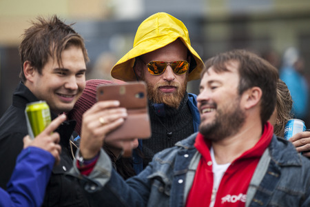 Traena, Norway - July 10 2015: group of friends looking at a selfie picture on a smartphone, Traenafestival, music festival taking place on the small island of Traenaのeditorial素材