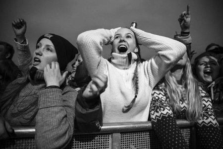 Traena, Norway - July 9 2015: fans cheering with arms up at concert of Norwegian rock band OnklP & De Fjerne Slektningene at Traenafestival, music festival taking place on the small island of Traenaのeditorial素材