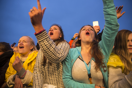 Traena, Norway - July 9 2015: fans cheering with arms up at concert of Norwegian rock band OnklP & De Fjerne Slektningene at Traenafestival, music festival taking place on the small island of Traenaのeditorial素材