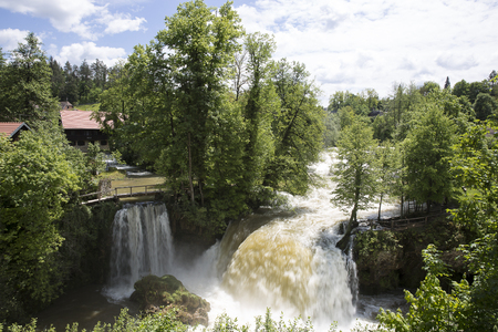 Croatian village of Rastoke by a river canyon with wooden houses in a green landscape with trees and a waterfall, Croatiaの写真素材