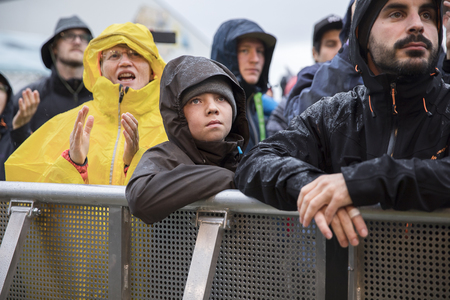 Traena, Norway - July 7 2017: amazed and admirative kid in the audience under the rain during concert of Norwegian pop singer Aurora at Traenafestival, music festival taking place on the small island of Traenaのeditorial素材