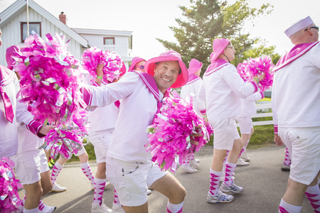 Men from the choir Oslo Fagottkor in their pink uniform participating in the Traena gay Pride during Traena festival, music festival taking place on the small island of Traenaのeditorial素材