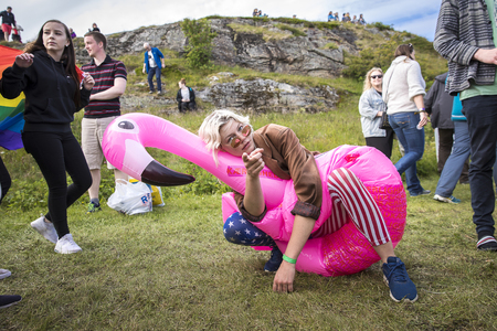 Traena, Norway - July 07 2017: singer from norwegian band Kuuk with inflating pink flamingo participating in Traena gay Pride during Traenafestival music festivalのeditorial素材