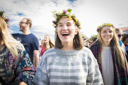 Traena, Norway - July 07 2017: woman with flower head wreath marching and cheering during Traena gay Pride in Europe during Traenafestival, music festival taking place on the small island of Traena.のeditorial素材
