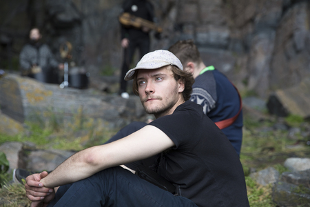 Traena, Norway - July 8 2017: thoughtful man in the audience at concert of Norwegian band Wardruna at cathedral cave Kirkehelleren on Sanna Island, at Traenafestival, music festival taking place on the small island of Traena.のeditorial素材