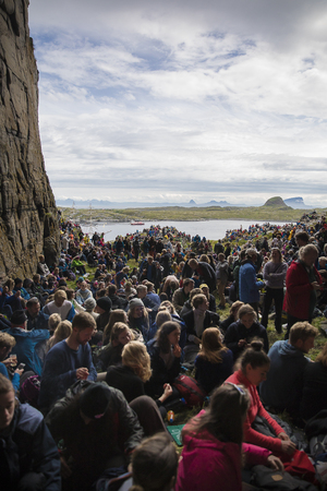 Traena, Norway - July 8 2017: audience with beautiful sea in the background during concert of Norwegian band Wardruna at cathedral cave Kirkehelleren on Sanna Island, at Traenafestival, music festival taking place on the small island of Traena.のeditorial素材