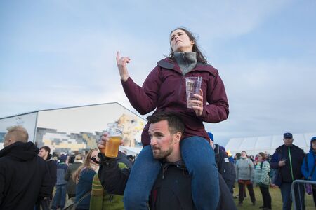 Traena, Norway - July 6 2017: woman sitting on a man shoulders, audience cheering at concert of American blues rock band Rafferty at Traenafestival, music festival taking place on the small island of Traenaのeditorial素材