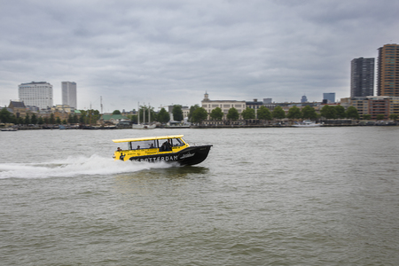 Rotterdam, The Netherlands - September 18, 2016: dynamic image of a Watertaxi sailing on the Nieuwe Maas canal from Wilhelminapier with modern cityscape in the background.のeditorial素材
