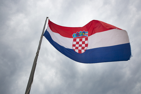 Croatian flag loating with a cloudy sky backgroundの写真素材