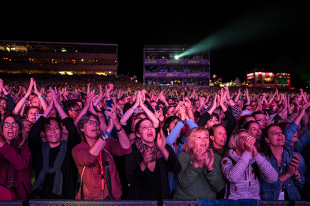 Nyon, Switzerland - 27 July 2019 :  very happy and excited young women in the audience, cheering, clapping and jumping at concert of French pop singer Patrick Bruelのeditorial素材