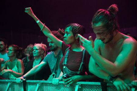 Nyon, Switzerland - 26 July 2019 :  audience with young black woman with her rist up, cheering  and dancing in front of concert of South African band BCUCのeditorial素材