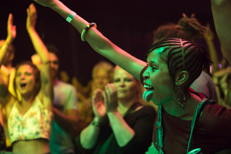 Nyon, Switzerland - 26 July 2019 :  audience with young black woman with her tongue out ,cheering  and dancing in front of concert of South African band BCUCのeditorial素材